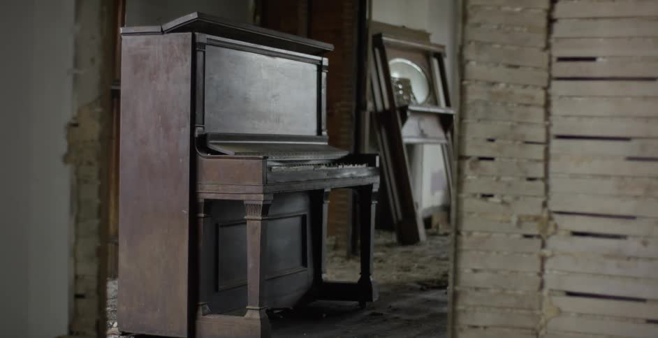 An old and abandoned piano in a room of a destroyed place