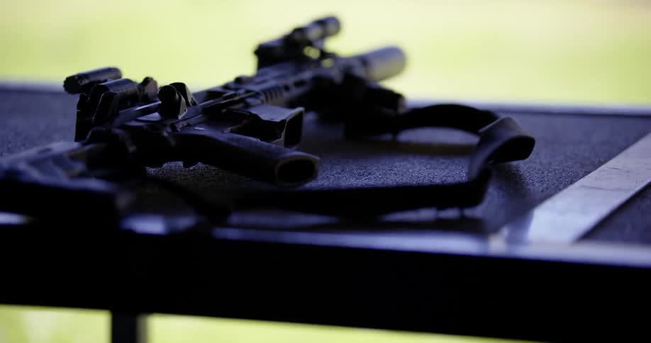 Automatic weapon laying on a countertop at an outdoor shooting range