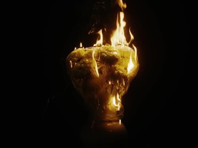 An object is burning with an incandescent flame and a black background