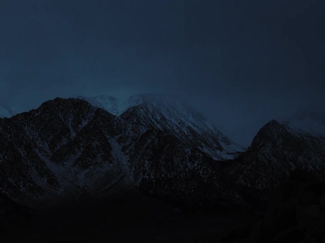 Mountain peaks under a night sky with snowcapped mountains at dusk