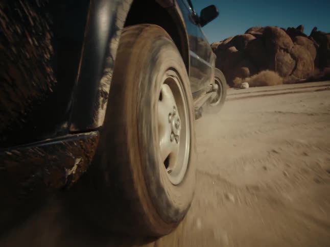 A vehicle drives in a circle on a dirt plain