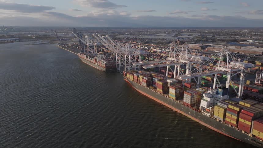 Aerial view of a busy port with numerous shipping containers and cranes