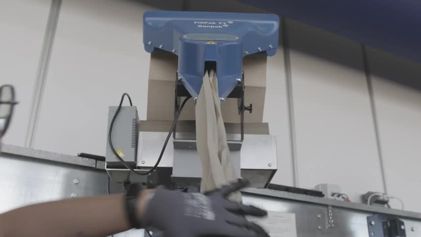 A woman removes packing paper from a dispensing machine