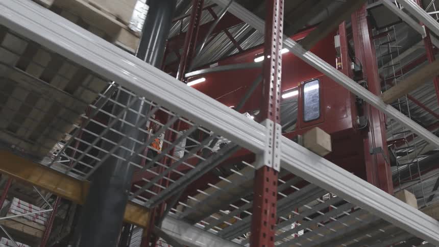 Reddish sheet metal being driven into warehouses with pallets