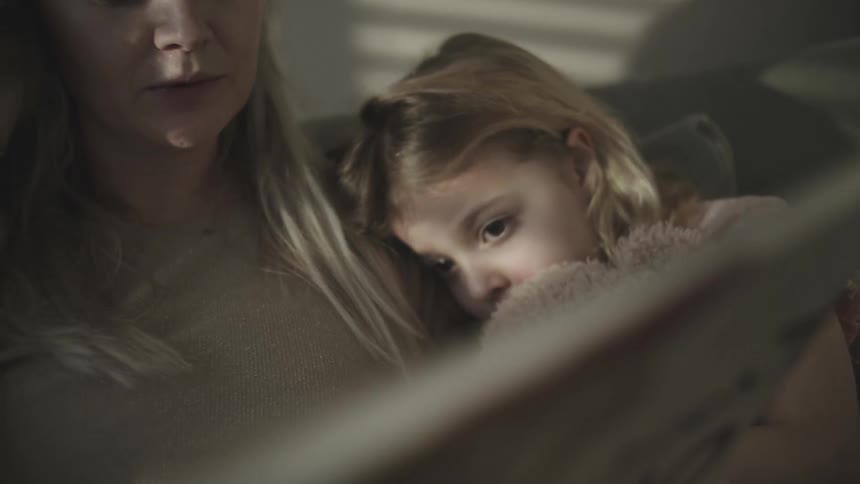 A clip of a woman and her daughters reading
