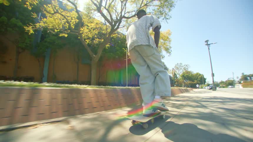 A skilled skateboarder effortlessly performs a trick on a sidewalk showcasing their impressive balance and control