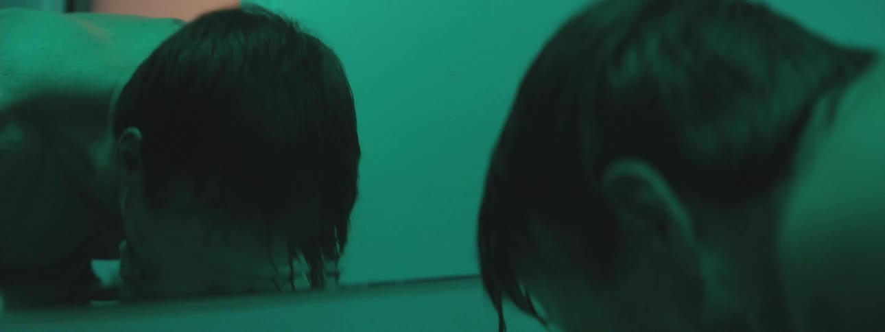 Portrait of a man washing his face in the bathroom and talking to himself in the mirror