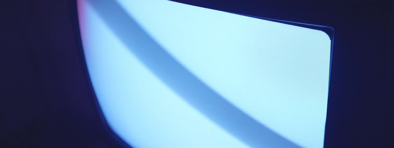 A closeup of a tv screen emitting blue light bright screen in a dark room