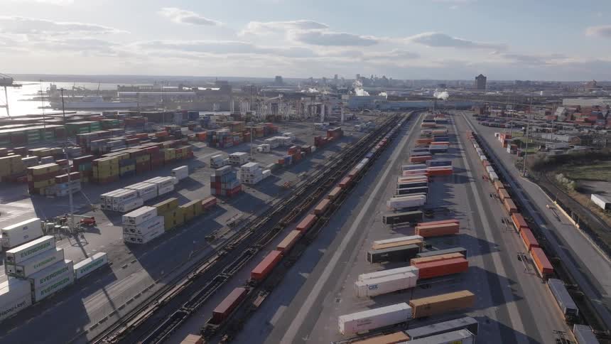 A busy train yard from above filled with colorful shipping containers and freight trains