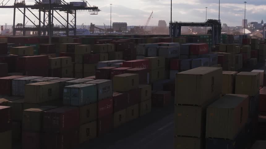 A place with many containers stacked on top of each other and some cranes