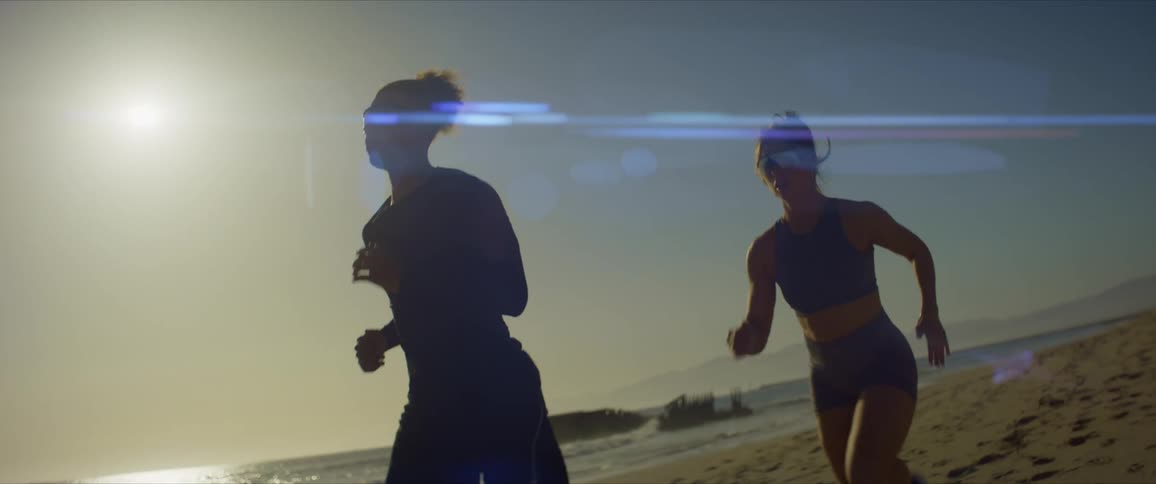 A man and a woman jogging on a beach