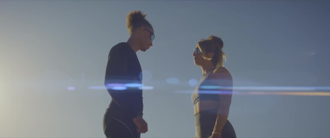 A man and a woman in exercise clothes give each other a fist bump