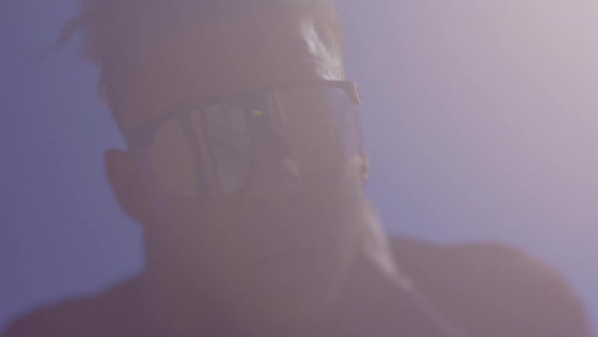 Close up of the face of a man wearing sunglasses under intense sunlight