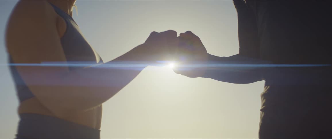 Closeup on a mans hands of a woman with closed hands touching fists