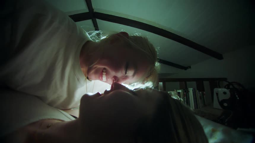 Two women are laying together in bed