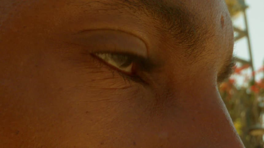 Person outside on a sunny day stares then looks down