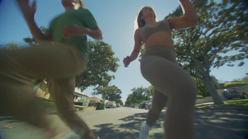 A young couple jogging in the neighborhood on a sunny day
