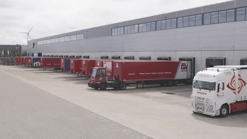 Aerial view of a logistics center and a person leaving with a small truck