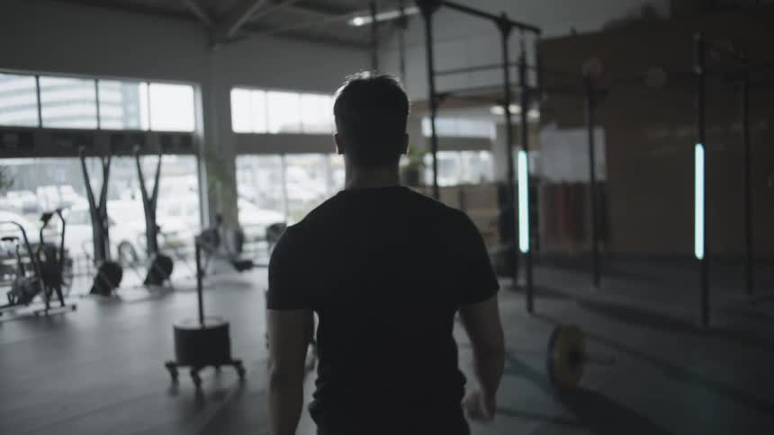 Man walks through gym toward windows facing parking lot