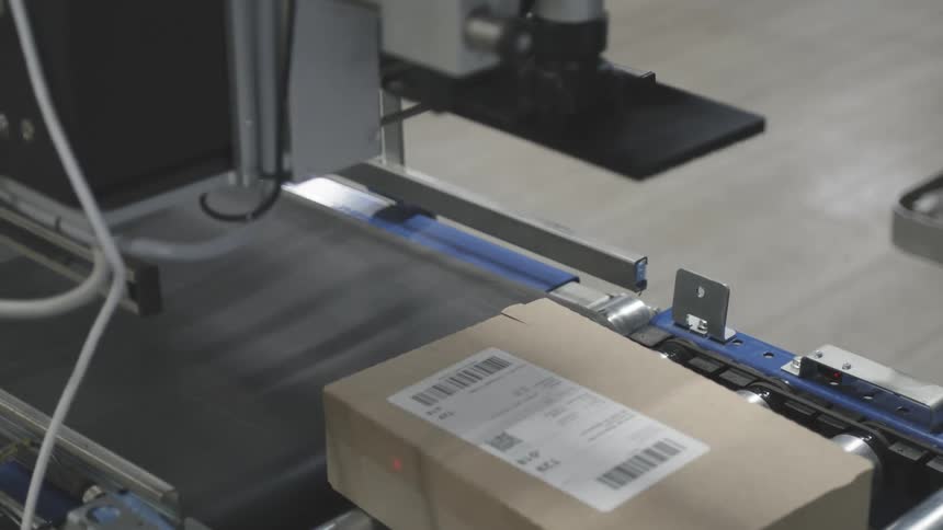 A machine is putting labels on boxes