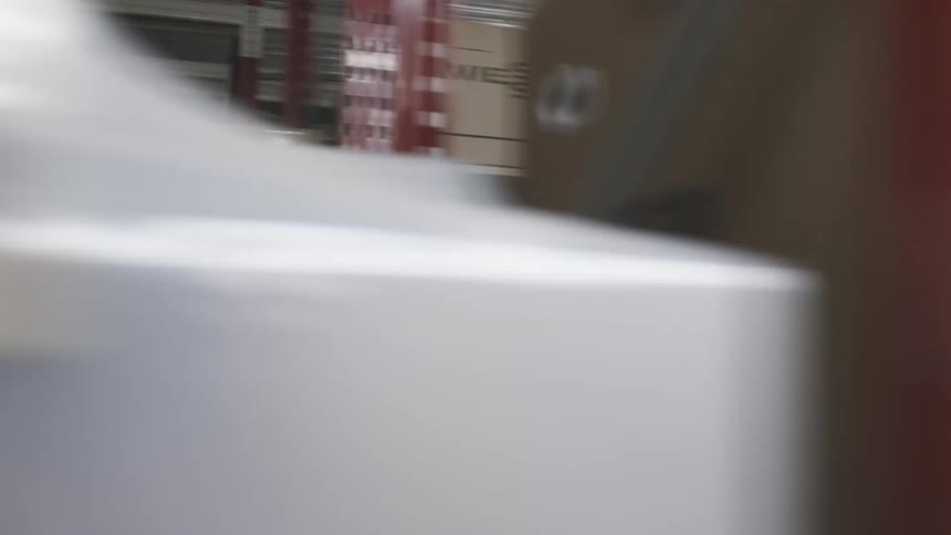 Cardboard boxes and other packages occupy shelving in warehouse