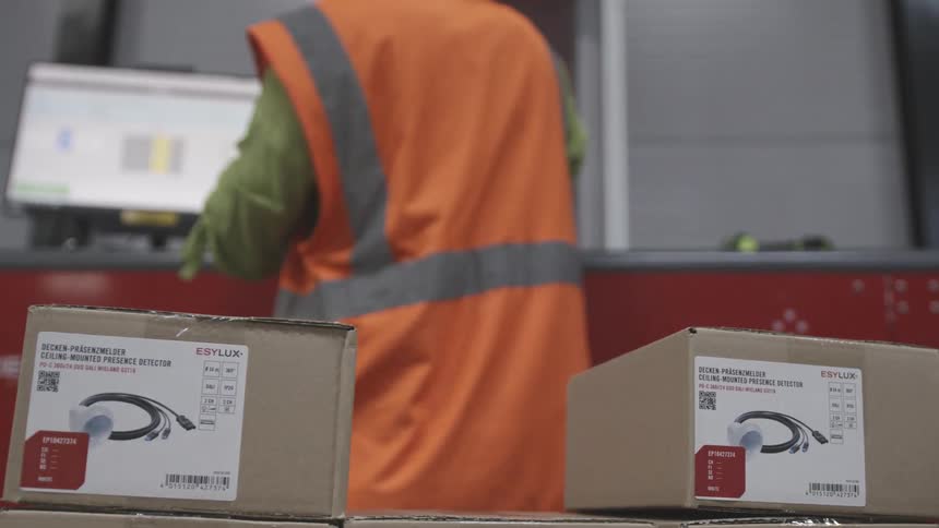 An employee moves packages to a desk