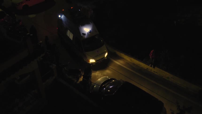 Vehicle with lights shining off it drives on dark road