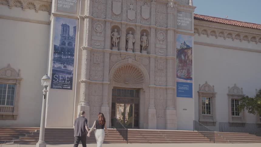 A man and a woman walk to a building on a college campus