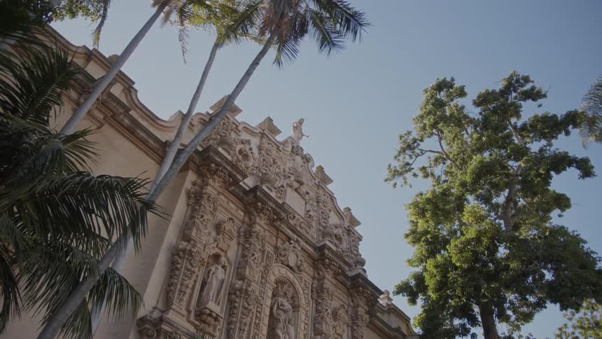 Facade of an old building with sculptures and trees around