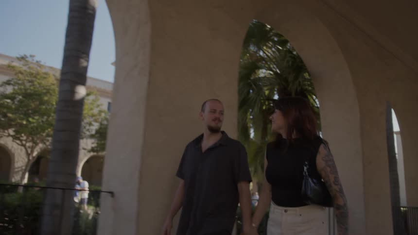 A man and a woman walk around a college campus