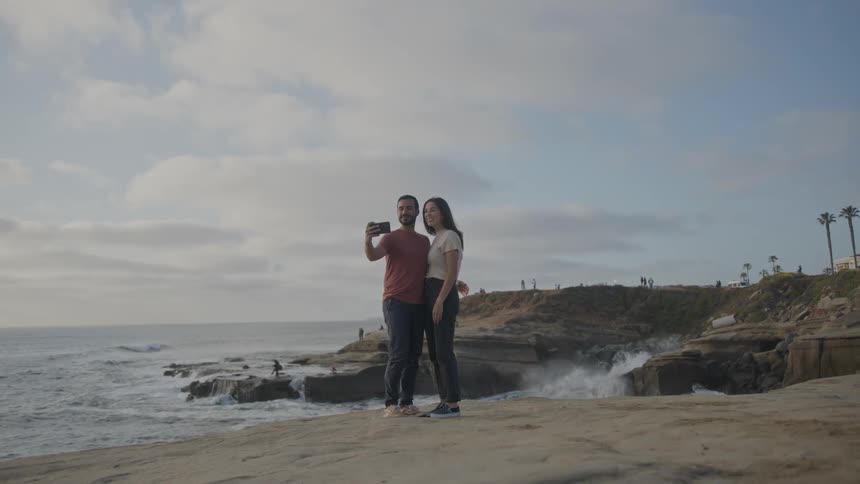 A footage of a couple taking a selfie at the beach