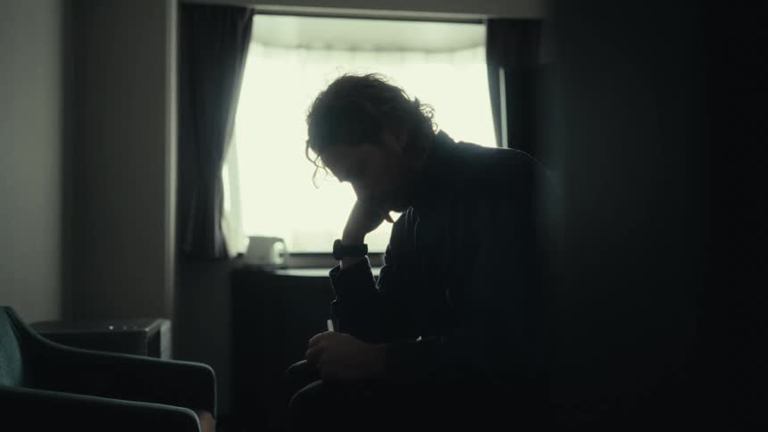 Man sitting in a room writing in a notebook