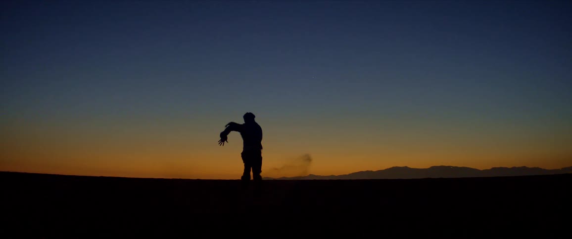 Landscape of a natural environment with dark blue and orange sky and the silhouette of a boy running