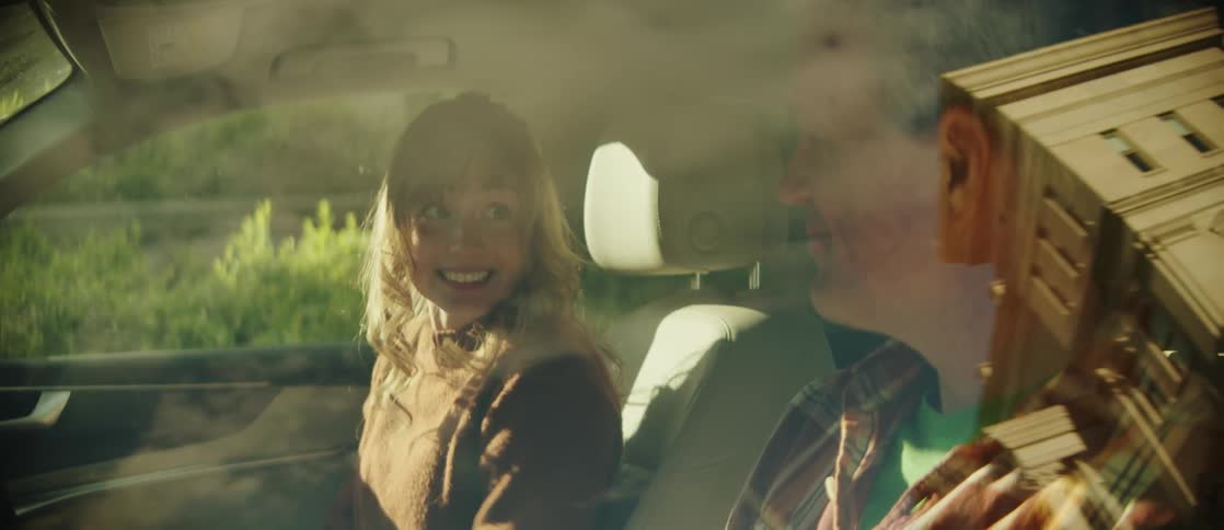 Father and daughter sitting inside a car the daughter is happily smiling and getting out of the car with excitement