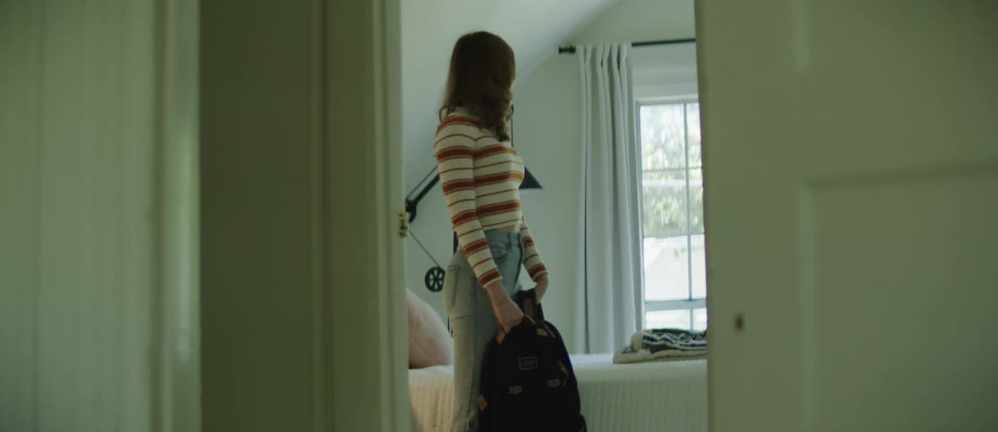 Young woman sitting on the bed gets up takes a backpack on her back and leaves the room