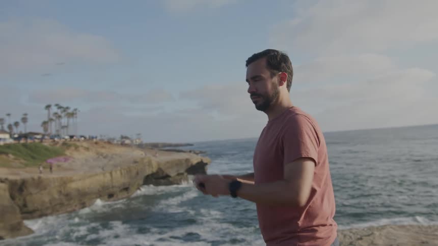 A clip of a man taking a video of the beach with a smart phone