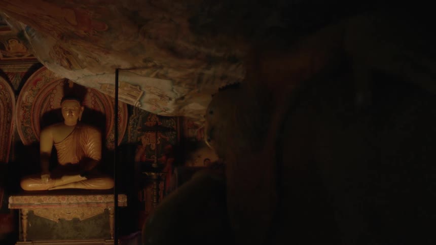 Interior with artistic and buddhist monuments in a dark room