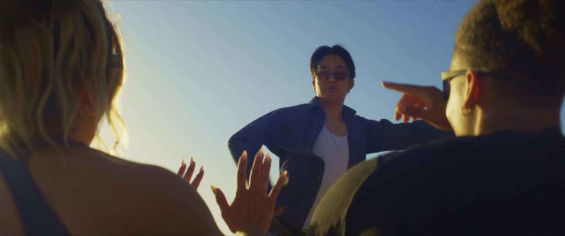 Man dancing in a natural environment while two people sitting enjoy and watch