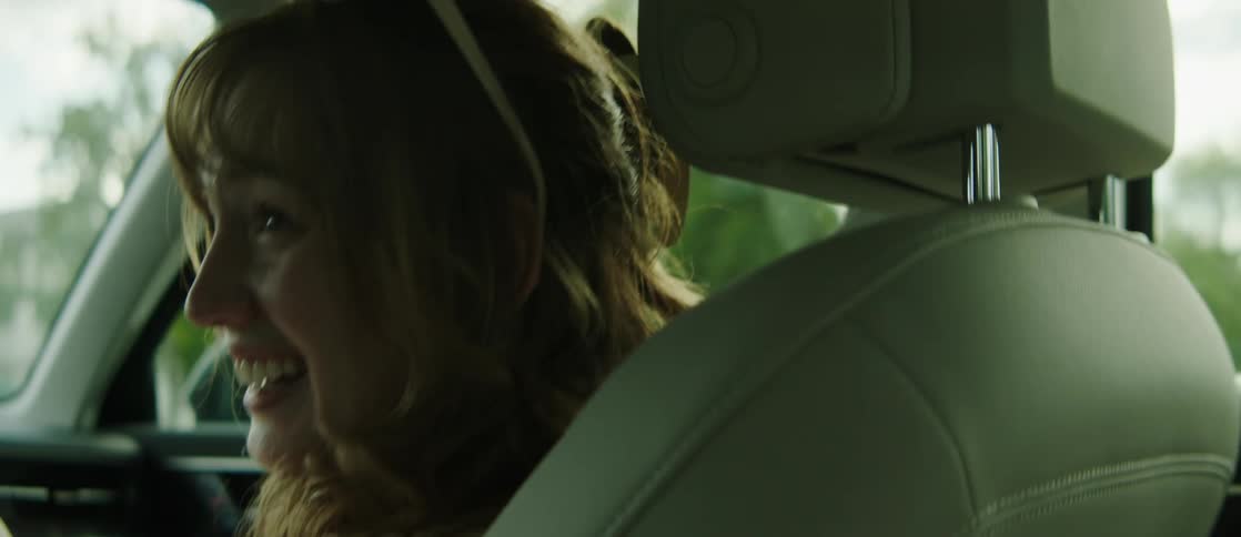 A woman talks as she rides in the car