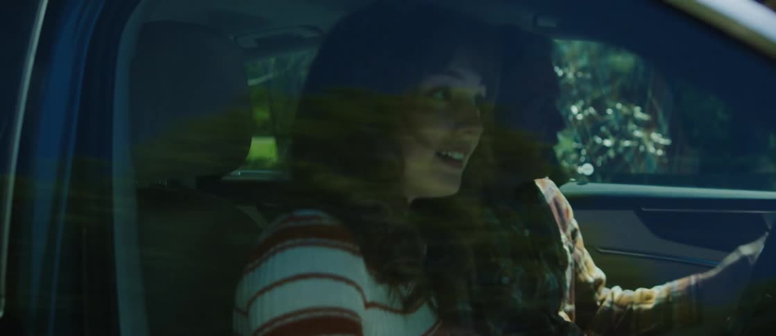 Young woman and a man getting into a car and closing the doors