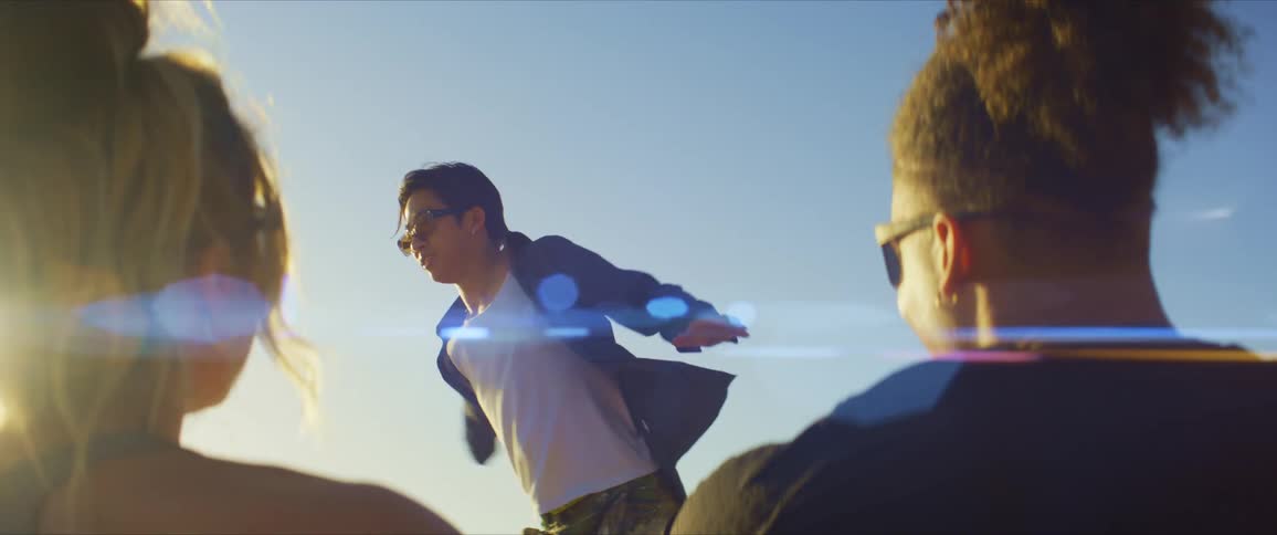 Man and woman enjoy watching dancer while sitting outdoors on a sunny day