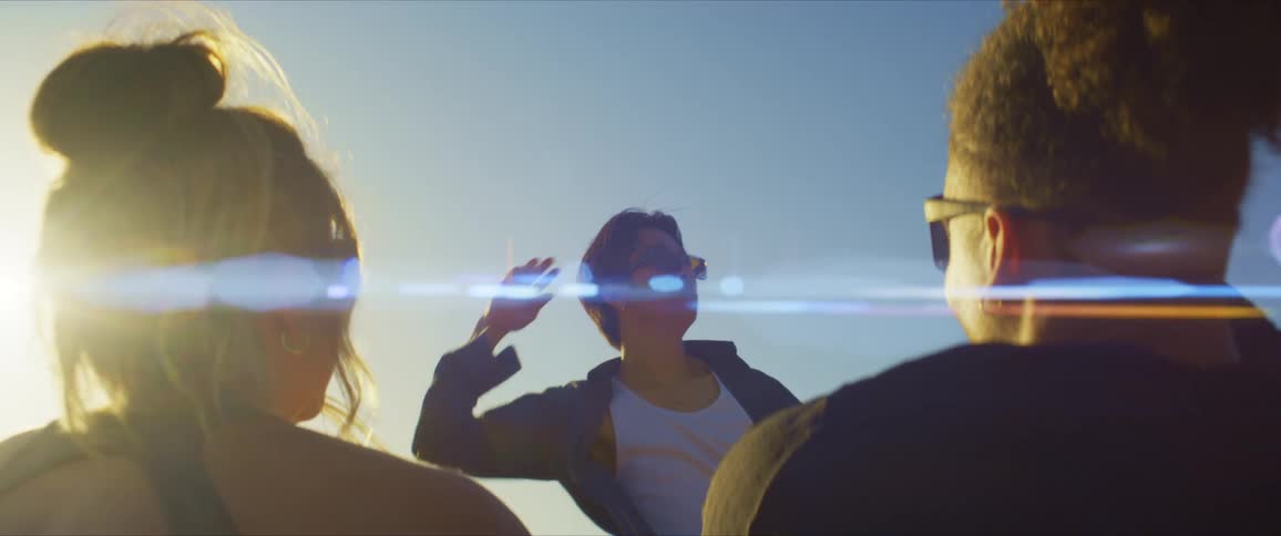 Two friends looking at a person dancing under a blue sky