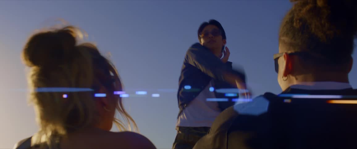 Young man in sunglasses dancing while two people seated enjoy the performance