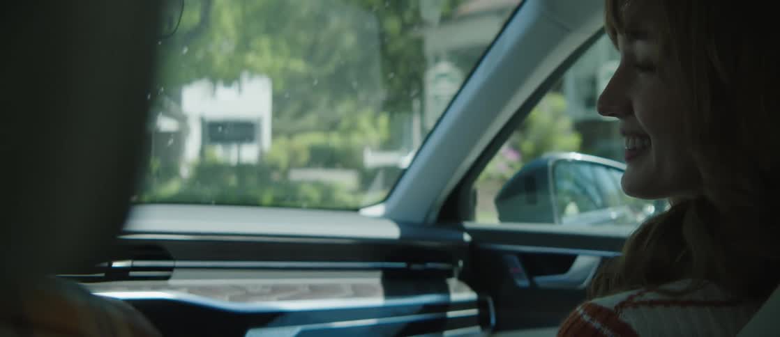 A woman is talking as she rides in the car