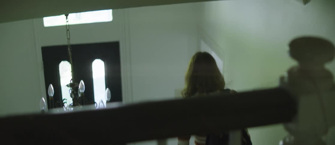 Redheaded woman walks down stairs and leaves the house