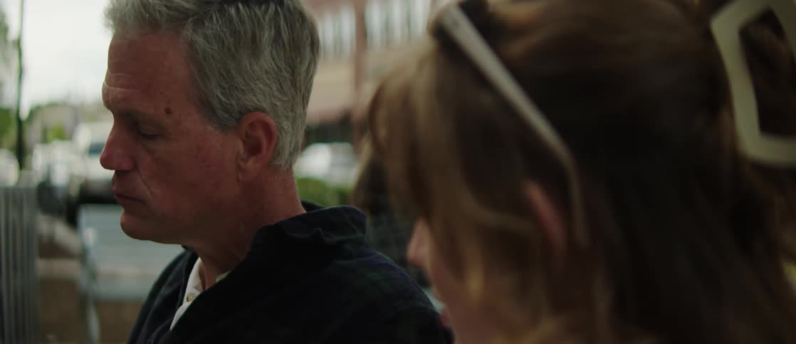 Portrait of an older man next to a young woman sitting and talking