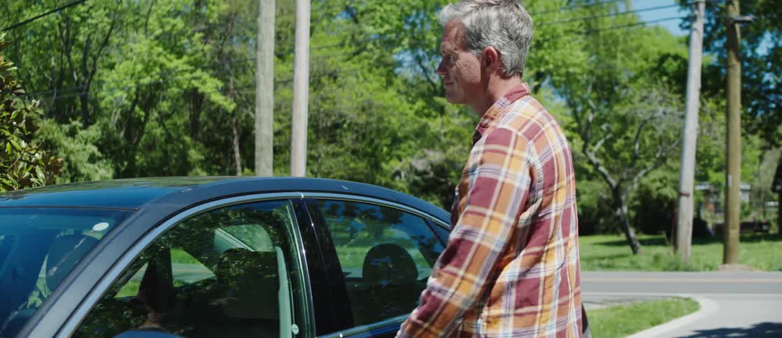 A father and his daughter get into a car after loading the trunk