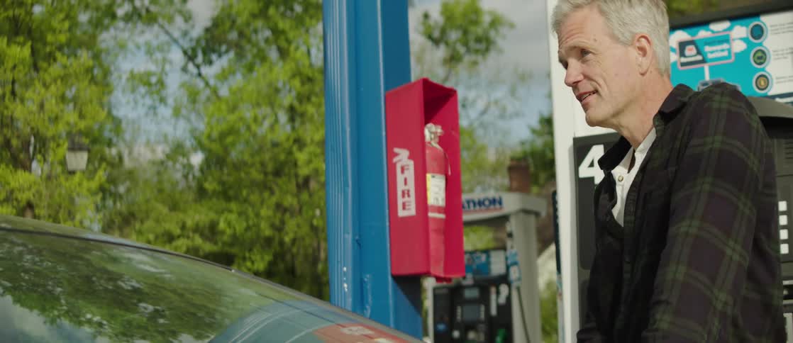 Man outside the car at a gas station filling up