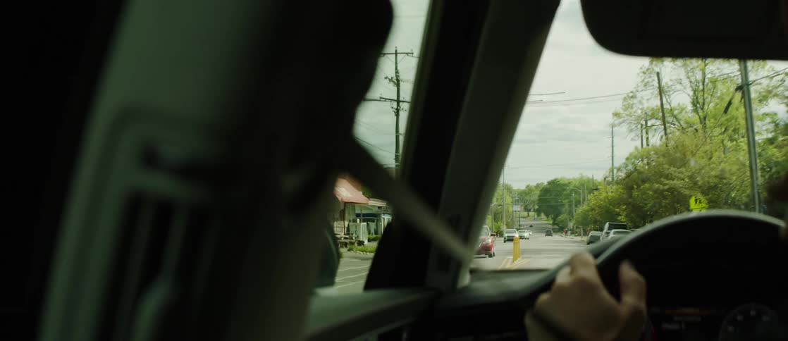 Persons hand on the steering wheel driving a vehicle