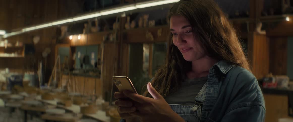 Young smiling woman texting and typing on iphone